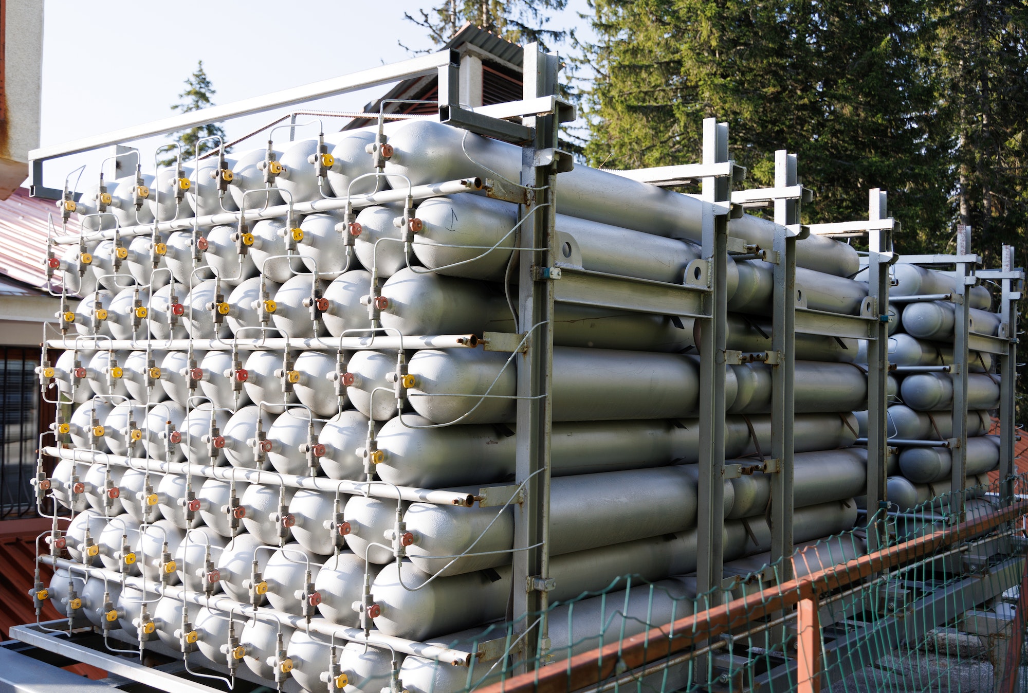 A lot of bottles filled with gas or gasoline are stacked in piles